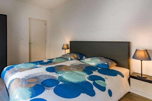 a bedroom with a bed with a blue and white comforter at Boven de ijsjes in Valkenburg