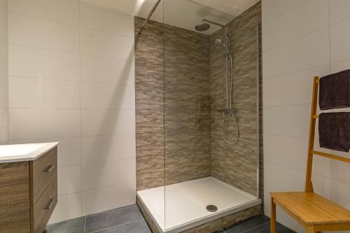 a shower with a glass door in a bathroom at Boven de ijsjes in Valkenburg