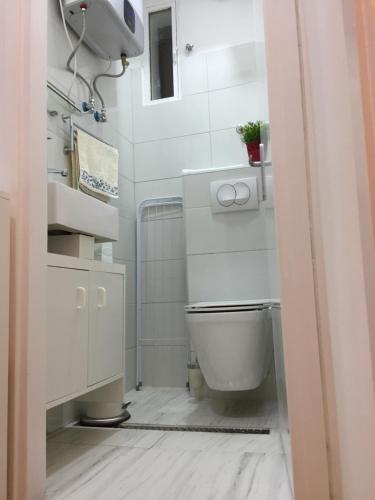 a white bathroom with a toilet and a sink at VERY CLOSE Studio Apartment in Zagreb