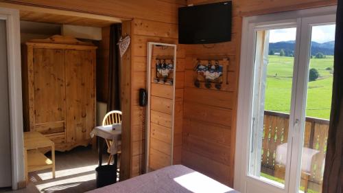 a room with a window and a tv on the wall at Hotel Restaurant LE YETI in Les Rousses