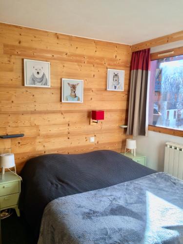 une chambre avec un lit et un mur en bois dans l'établissement Duplex skis aux pieds Belle Plagne, à Belle Plagne