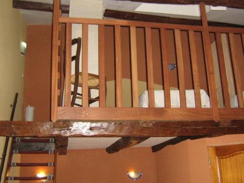 a wooden staircase in a room with a ladder at Logîte Touristique Les 3 Loups in Châtenois