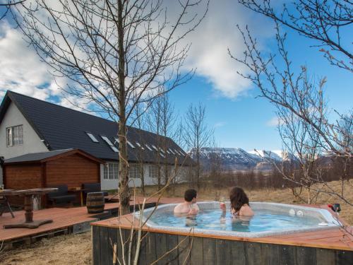 dos personas en un jacuzzi en un patio trasero en Hotel Laxnes, en Mosfellsbær