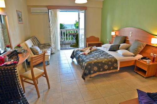 a bedroom with a bed and a table and a chair at Belussi Beach Hotel & Suites in Kipseli