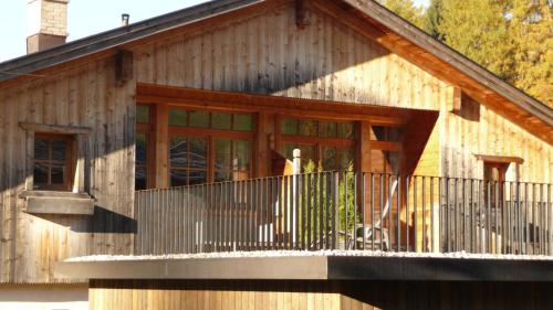a wooden house with a balcony and a porch at Appartement Pichler in Dobbiaco