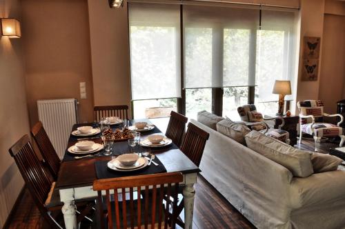 a living room with a table and a couch at Chalet Coquelicot (Co-cli-co) relax in nature in Kalavrita