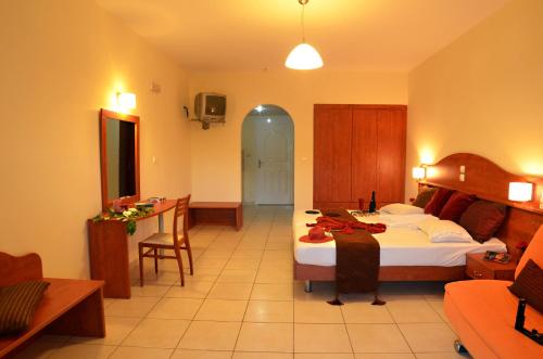 a hotel room with a bed and a desk and a room at Belussi Beach Hotel & Suites in Kipseli