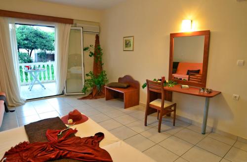 a living room with a table and a mirror at Belussi Beach Hotel & Suites in Kipseli