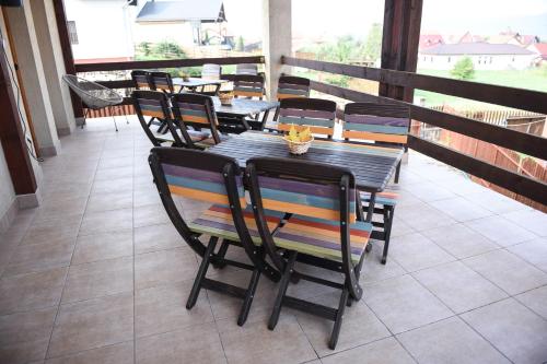 a wooden table and chairs on a balcony at Pension Panorama in Odorheiu Secuiesc
