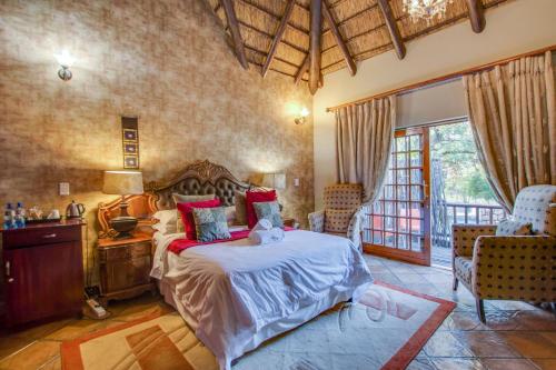 een slaapkamer met een bed en een tafel en stoelen bij Kassaboera Lodge in Hartbeespoort