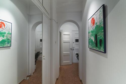 korytarz z dwoma obrazami na ścianach i korytarz z drzwiami w obiekcie Cutie by Stylish Stays w Atenach