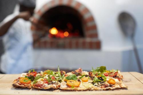 a pizza sitting on a table in front of a oven at President Hotel in Cape Town
