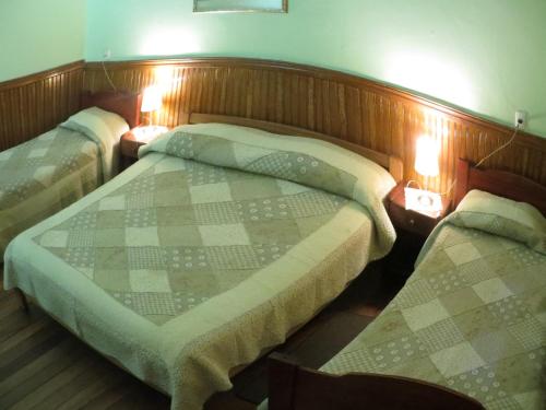 Dos camas en una habitación con dos luces. en Hostal El Rincon Marino, en Valparaíso