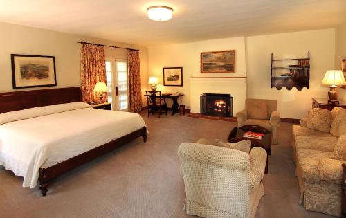 a bedroom with a bed and a living room with a fireplace at Arizona Inn in Tucson