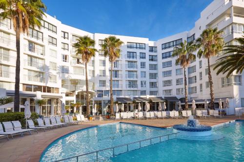 a swimming pool in front of a large building at President Hotel in Cape Town