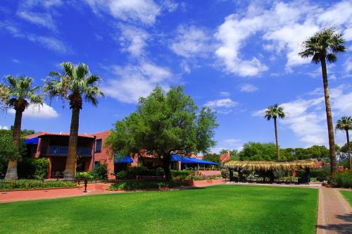 a park with palm trees in front of a building at Arizona Inn in Tucson