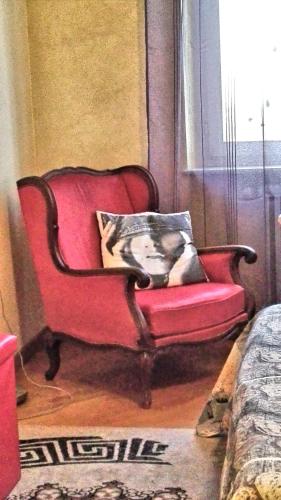 a red couch in a living room with a pillow at Luna del Belvedere in Asti