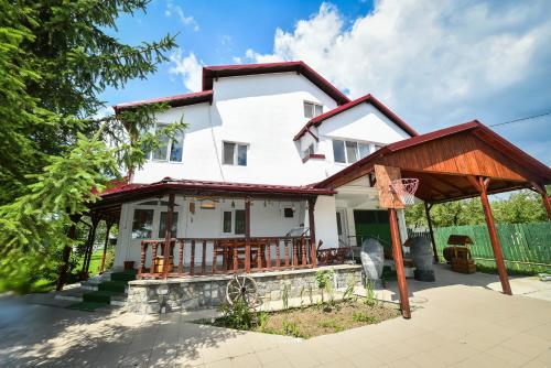 a white house with a porch with a roof at Villa Bravo Breaza in Breaza