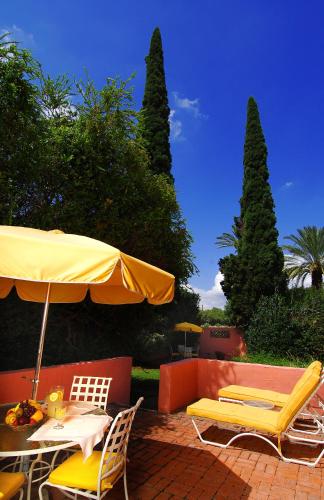 a patio with a table and chairs and an umbrella at Arizona Inn in Tucson