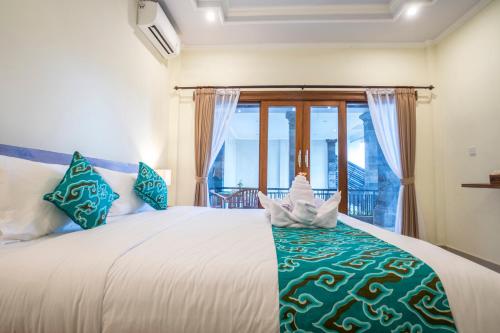 a bedroom with a large bed with a window at Darba Guest House Ubud in Ubud