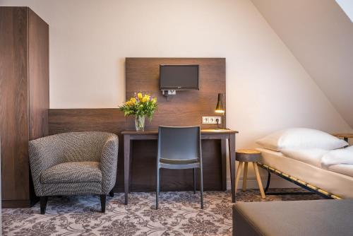 a hotel room with a desk and a bed at Signature Hotel Astoria in Hamburg