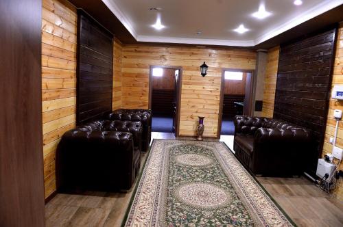 a room with leather chairs and a rug at Pride Hotel in Taraz
