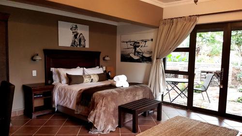 a bedroom with a bed and a sliding glass door at Barnstormers Rest in Malelane