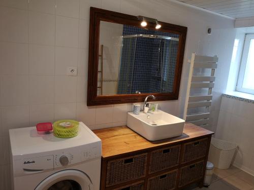 een badkamer met een wastafel en een wasmachine bij Les gîtes d'Herquetot "Les Genets" in Vasteville