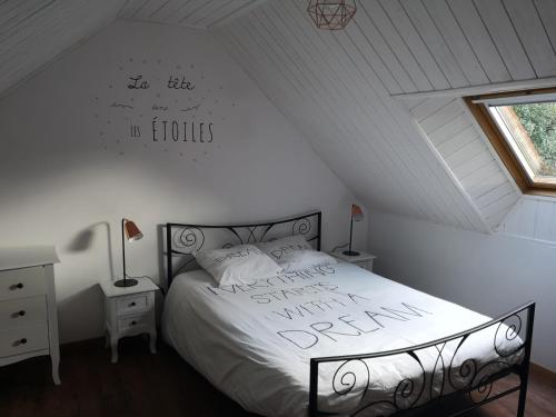 ein Schlafzimmer mit einem Bett mit einem Schild an der Wand in der Unterkunft Les gîtes d'Herquetot "Les Genets" in Vasteville
