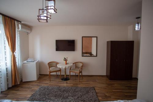 - un salon avec une table et deux chaises dans l'établissement Casa Alex, à Târgu Jiu