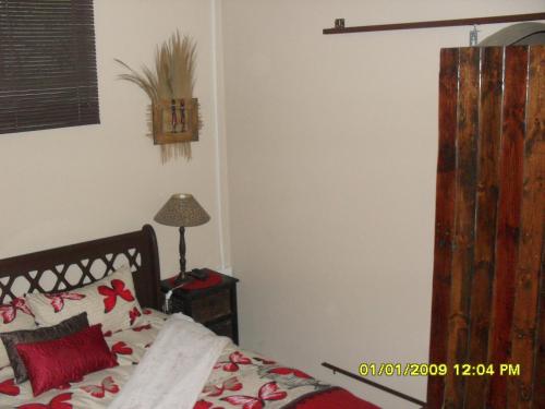 een slaapkamer met een bed en een tafel met een lamp bij Silvermoon in Nigel