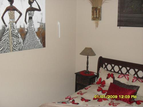 - une chambre avec un lit et une photo sur le mur dans l'établissement Silvermoon, à Nigel