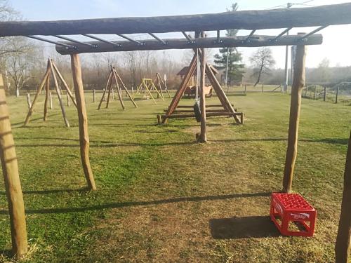 a playground with a red box in a field at Etno selo EDEN in Žeravački Potok