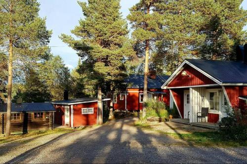 eine Straße neben einem roten Haus und Bäumen in der Unterkunft Aurora Camp Kurravaara in Kurravaara