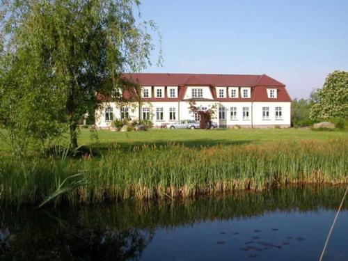Un gran edificio blanco al lado de un cuerpo de agua. en Ferienzimmer Günther Objekt 28985, en Rostock