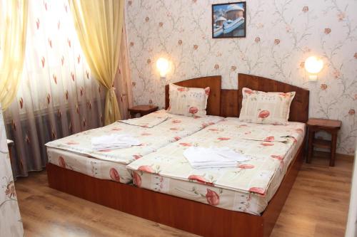 a bedroom with a large bed with flowers on it at Hotel Trakia in Pazardzhik