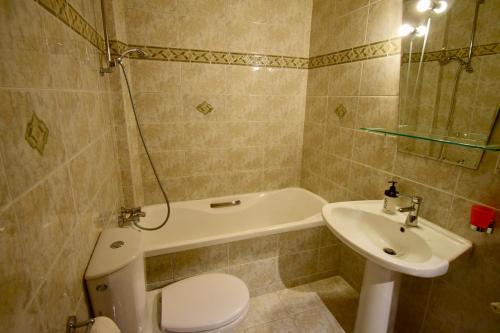 a bathroom with a toilet and a sink and a tub at Sun City View in Thessaloniki
