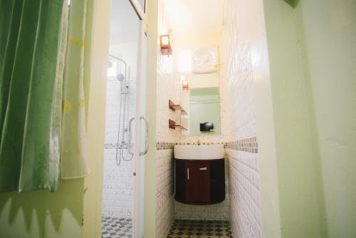 y baño pequeño con lavabo y ducha. en SuanTung Coffee & Guesthouse en Chiang Rai