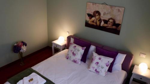 a bedroom with a bed with white sheets and pink pillows at A Casa di Grace in Basiglio