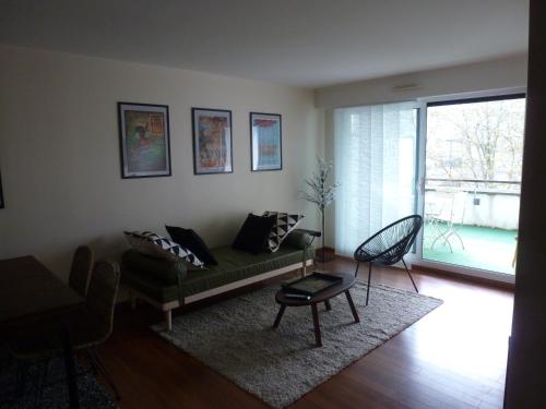 un salon avec un canapé et une table dans l'établissement Appartement 3 pièces coeur de ville, à Lorient
