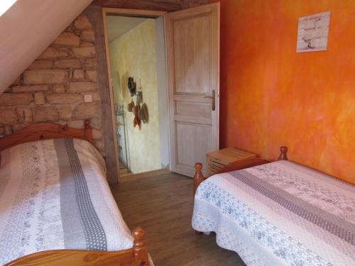 a bedroom with two beds and an open door at Chambres d'hôtes Les Arondelles in Virey-le-Grand