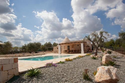 uma piscina num quintal com uma casa em Trullo Oasi Santo Stefano - private pool em Castellana Grotte