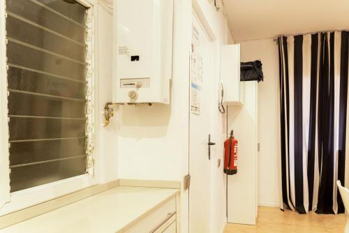 a kitchen with a window and a red fire extinguisher at Nice apartment in the middle of Born in Barcelona