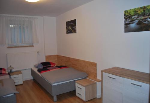 a small bedroom with a bed and a desk at Apartament Rodzinny in Szklarska Poręba
