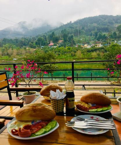 two plates of food on a table with a view at Bac Ha Boutique Homestay in Bắc Hà