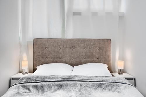 a bedroom with a large bed with two lamps at Apartament Wyzwolenia - Unique Apartments in Szczecin