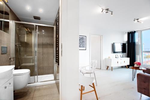 a bathroom with a shower and a toilet and a sink at Apartament Wyzwolenia - Unique Apartments in Szczecin
