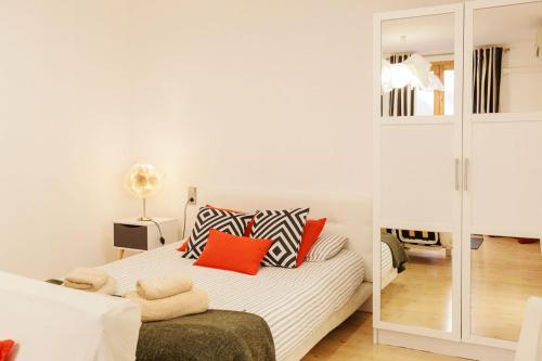 a bedroom with a white bed with red pillows at Nice apartment in the middle of Born in Barcelona
