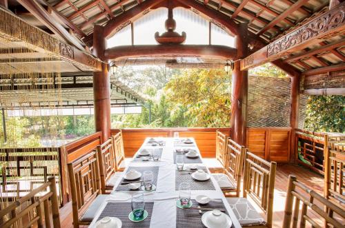 a dining room with a long table and chairs at Cat Tien Jungle Lodge in Cat Tien