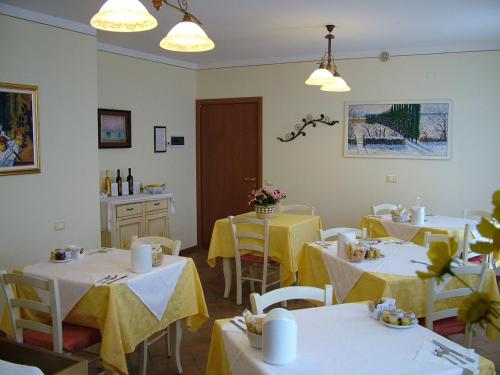 a restaurant with tables and chairs with yellow table cloth at BB Mambrotta in San Martino Buon Albergo